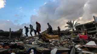Palestinian children look for salvageable items in the rubble in Rafah, on the southern Gaza Strip,