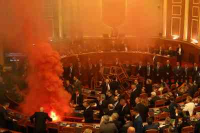Albania’s opposition Democratic Party members set off smoke bombs and lit a fire in the middle of parliament in a failed attempt to stop the chamber voting on next year’s budget
